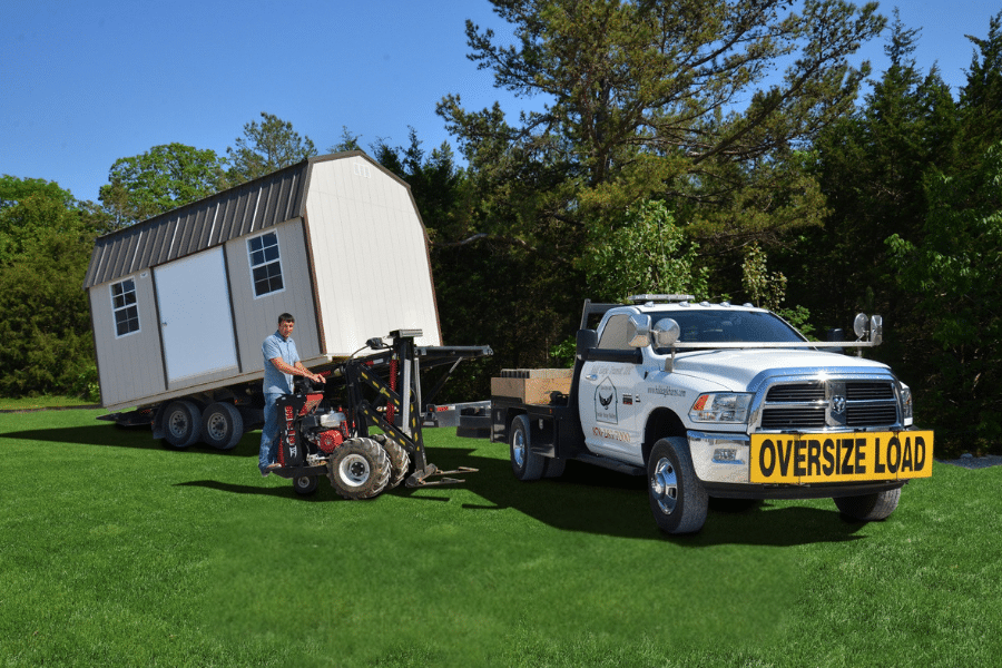 shed moving equipment with truck moving a shed.