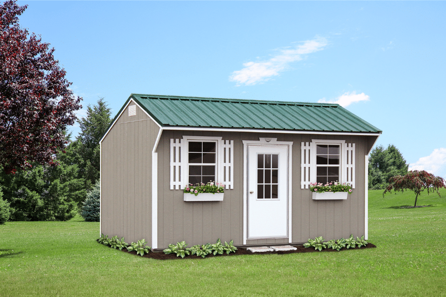 tan quaker shed with white trim and green metal roof